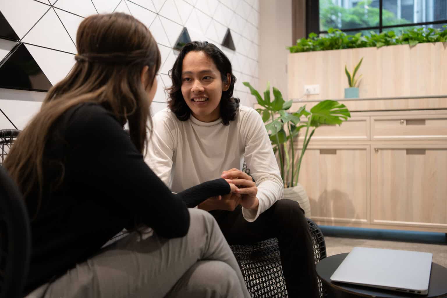 Young businesswoman having professional conversation with male colleague indoors